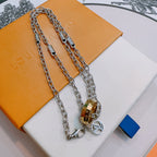 Silver-tone layered chain necklace with gold-tone lock pendant and ring charm