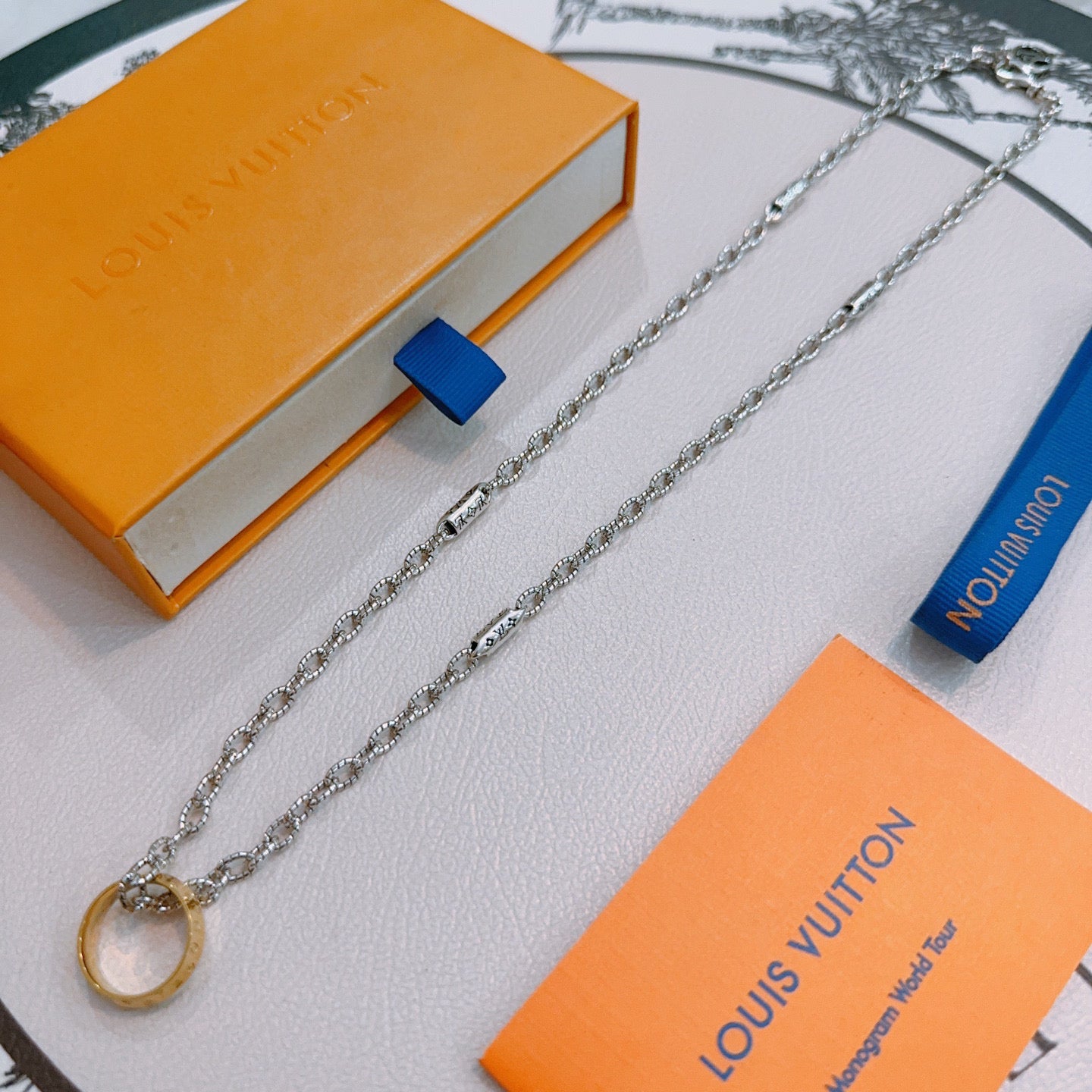 Silver-tone chain necklace with ring charm and lock-shaped gold pendant