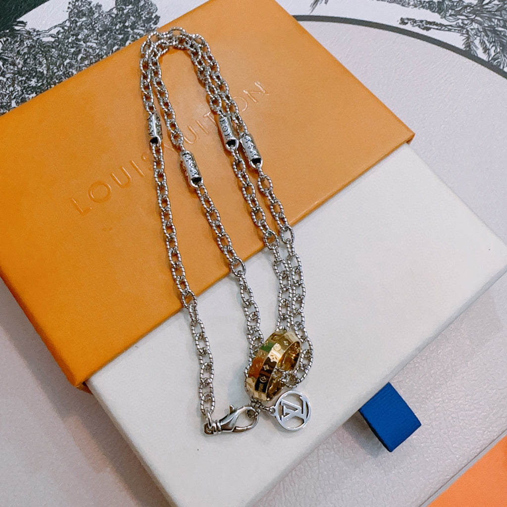 Silver-tone layered chain necklace with gold-tone lock pendant and ring charm