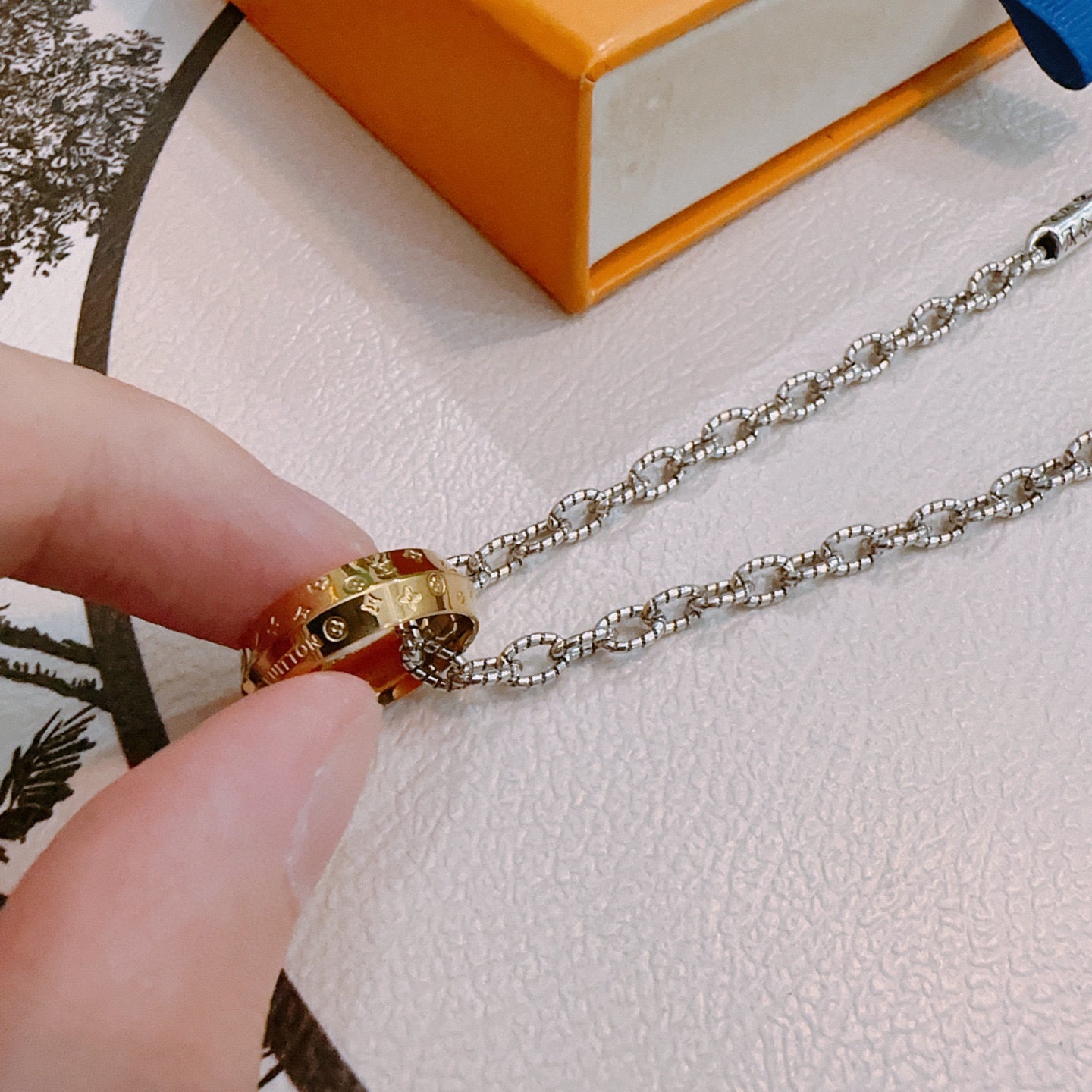 Silver-tone chain with gold-tone lock charm and engraved details