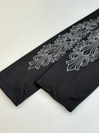 Black long-sleeve top with ornate floral graphic along sleeve edge.