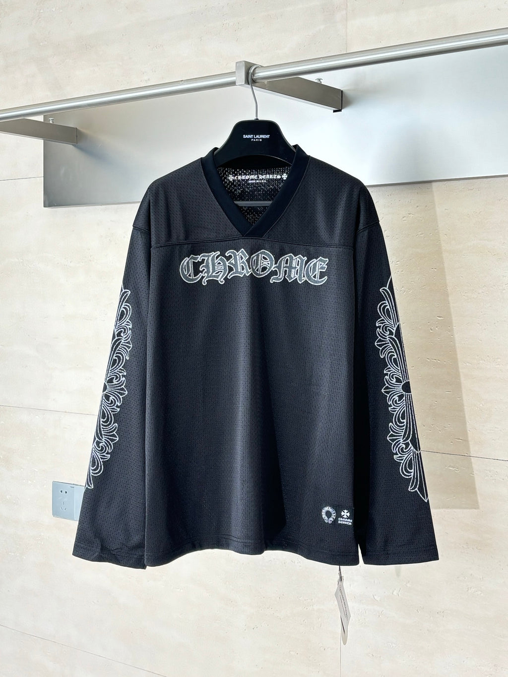 Black graphic long-sleeve top with V-neck and front logo lettering.