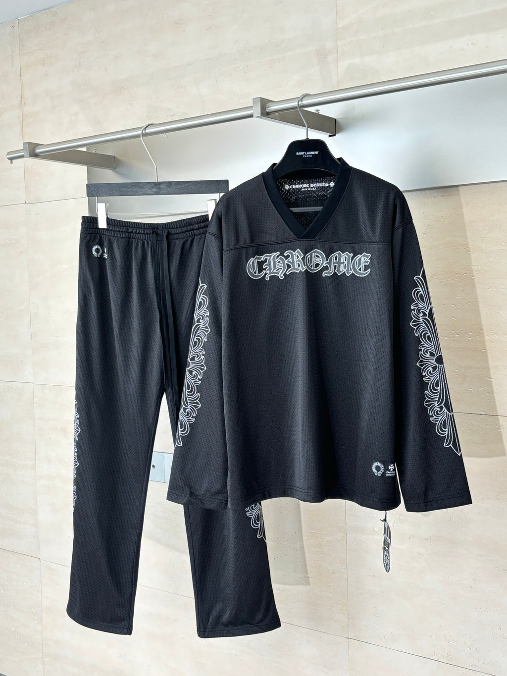 Black long-sleeve top and matching drawstring pants with graphic sleeve accents.