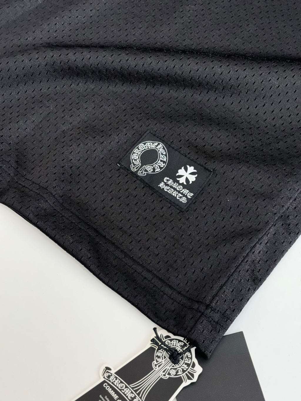 Black long-sleeve top with small brand label near hem and sleeve logo.