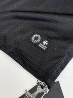 Black long-sleeve top with small brand label near hem and sleeve logo.