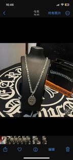 Silver-tone chain necklace with oval medallion pendant on stand, full front view.