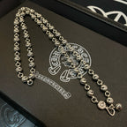 Silver beaded ball chain necklace set on a black box with engraved emblem.