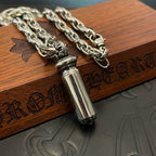 Chrome capsule pendant necklace close-up with detailed chain links and metal tip