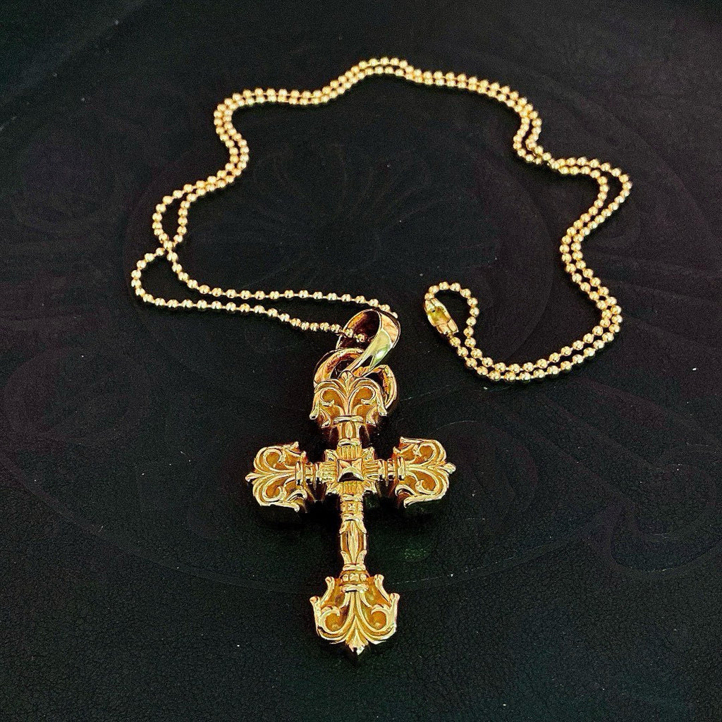 Gold tone cross pendant on beaded ball chain, shown laid flat