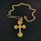 Gold tone cross pendant on beaded ball chain, shown laid flat