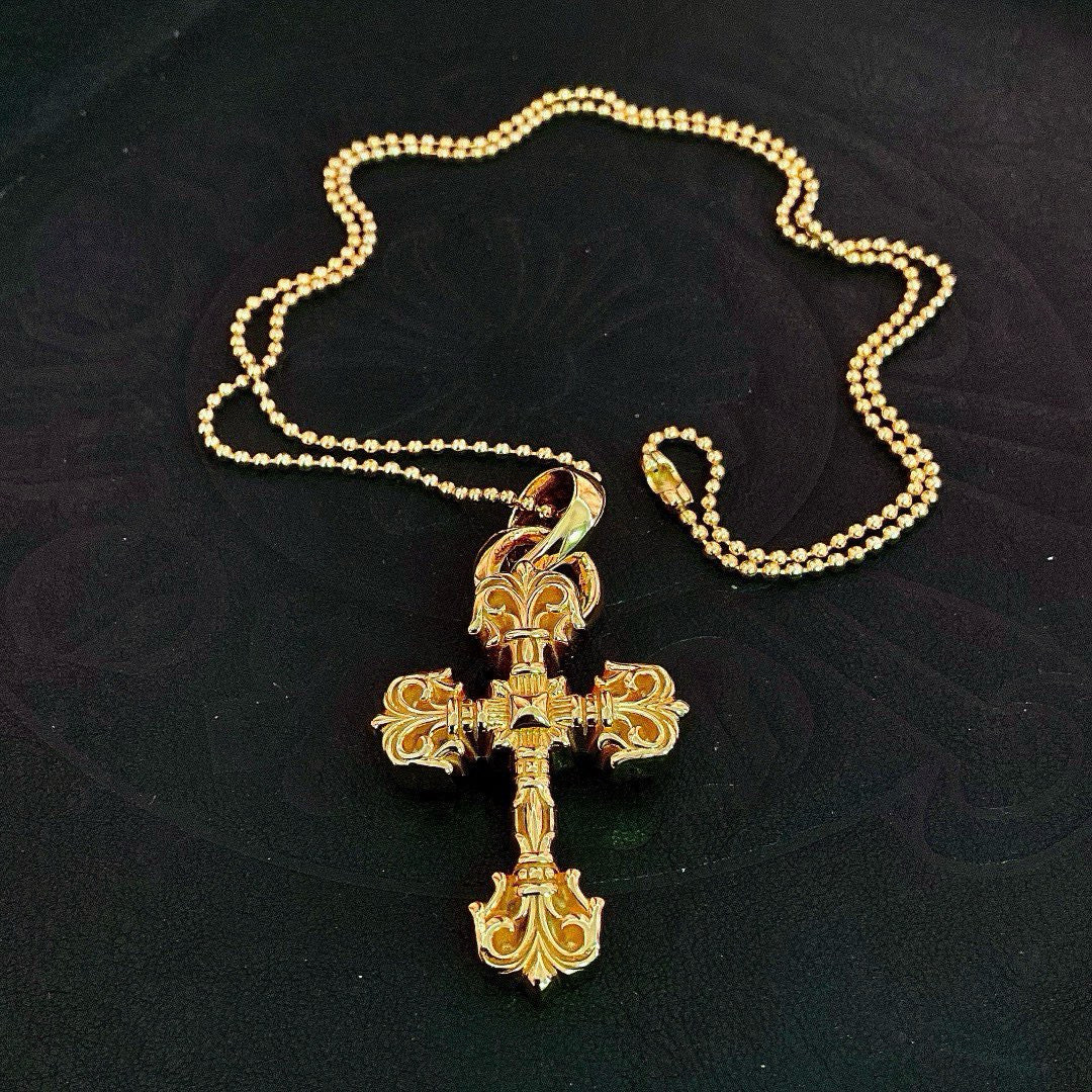 Gold tone cross pendant on beaded ball chain, shown laid flat
