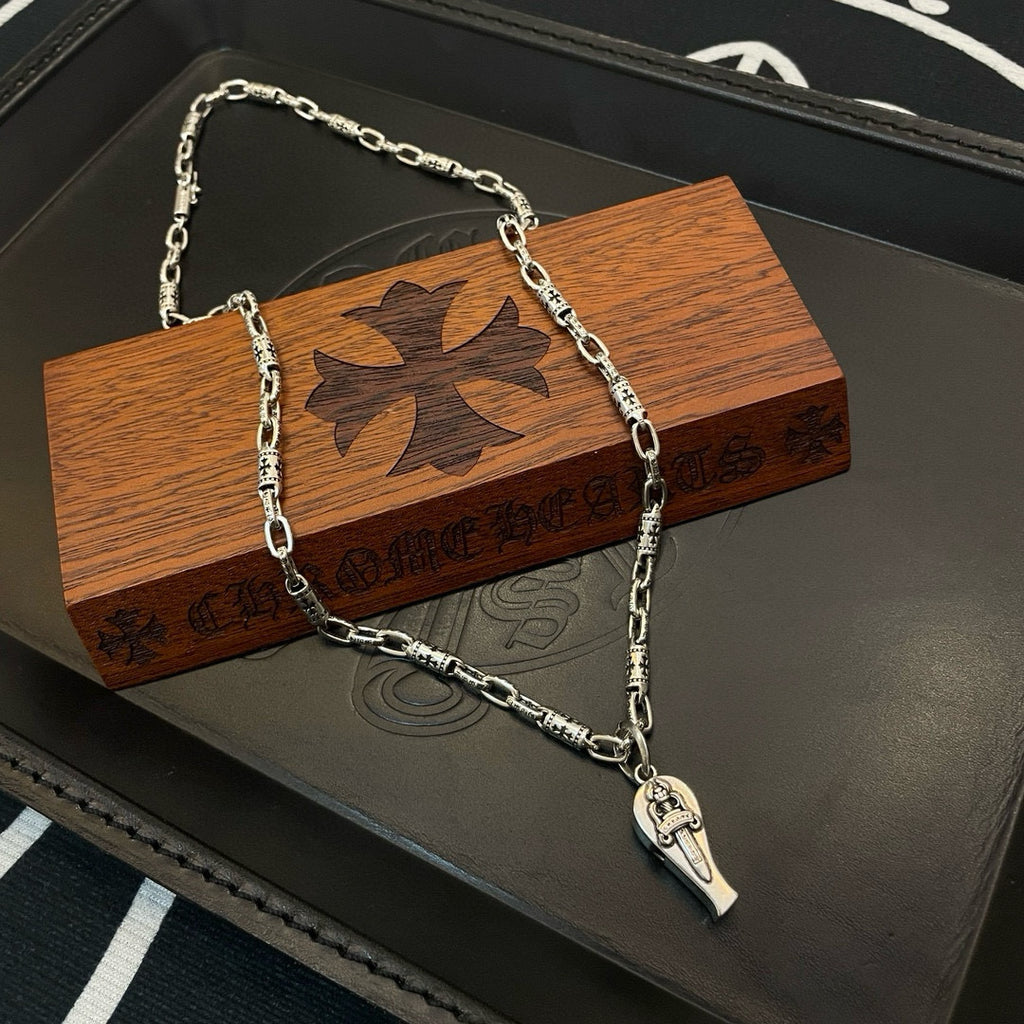 Silver-tone pendant chain necklace with pointed charm on black box and wood case