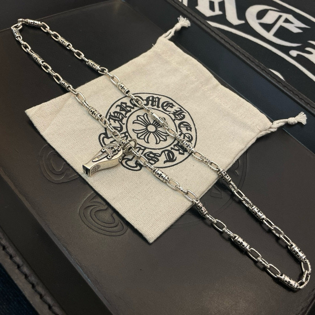 Silver-tone chain necklace with pendant charms and white drawstring pouch