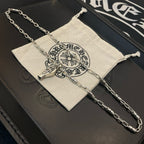 Silver-tone chain necklace with pendant charms and white drawstring pouch