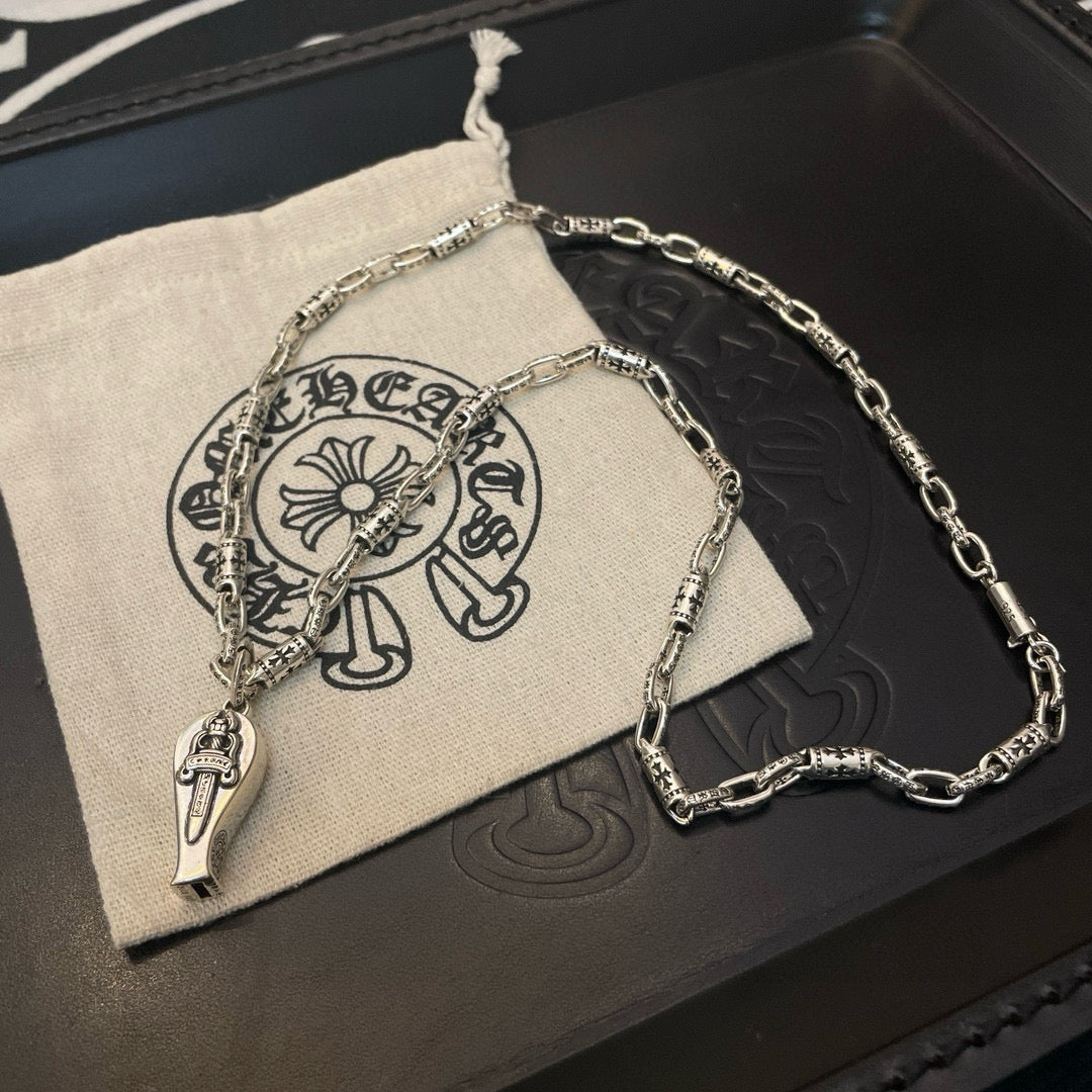 Silver-tone chain necklace with pendant charm on black box with small pouch