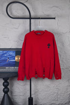 Red long-sleeve crewneck sweater with black embroidered motifs on chest