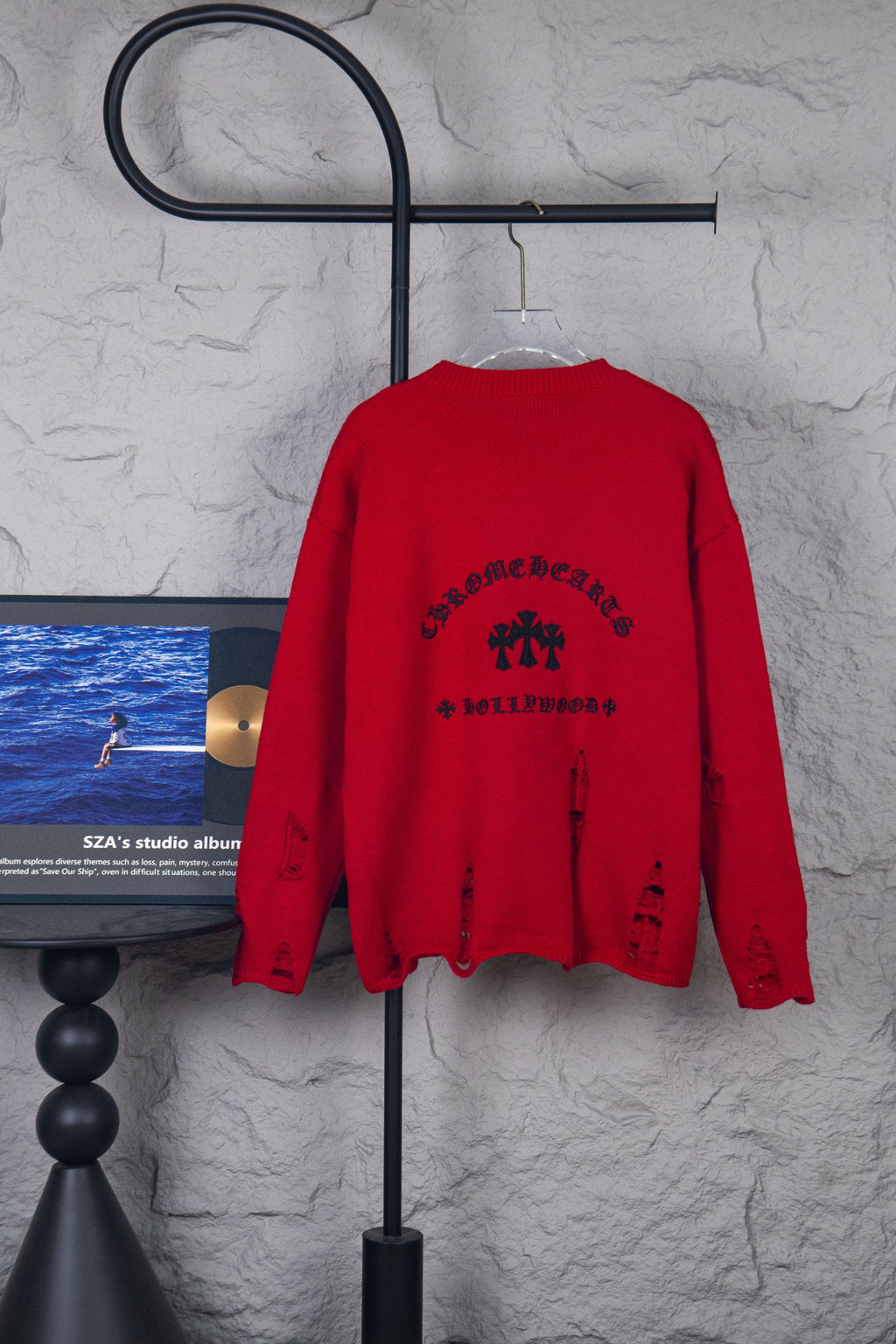 Red crewneck sweater with black arched text and cross-style back graphic