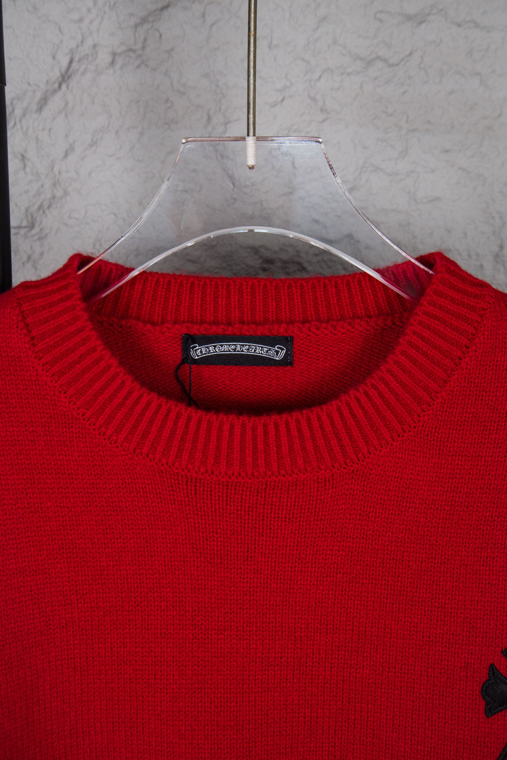 Red crewneck sweater close-up with ribbed collar and neckline label