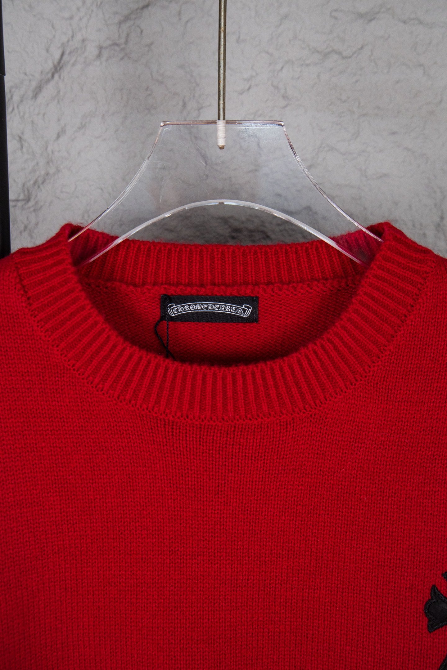 Red crewneck sweater close-up with ribbed collar and neckline label