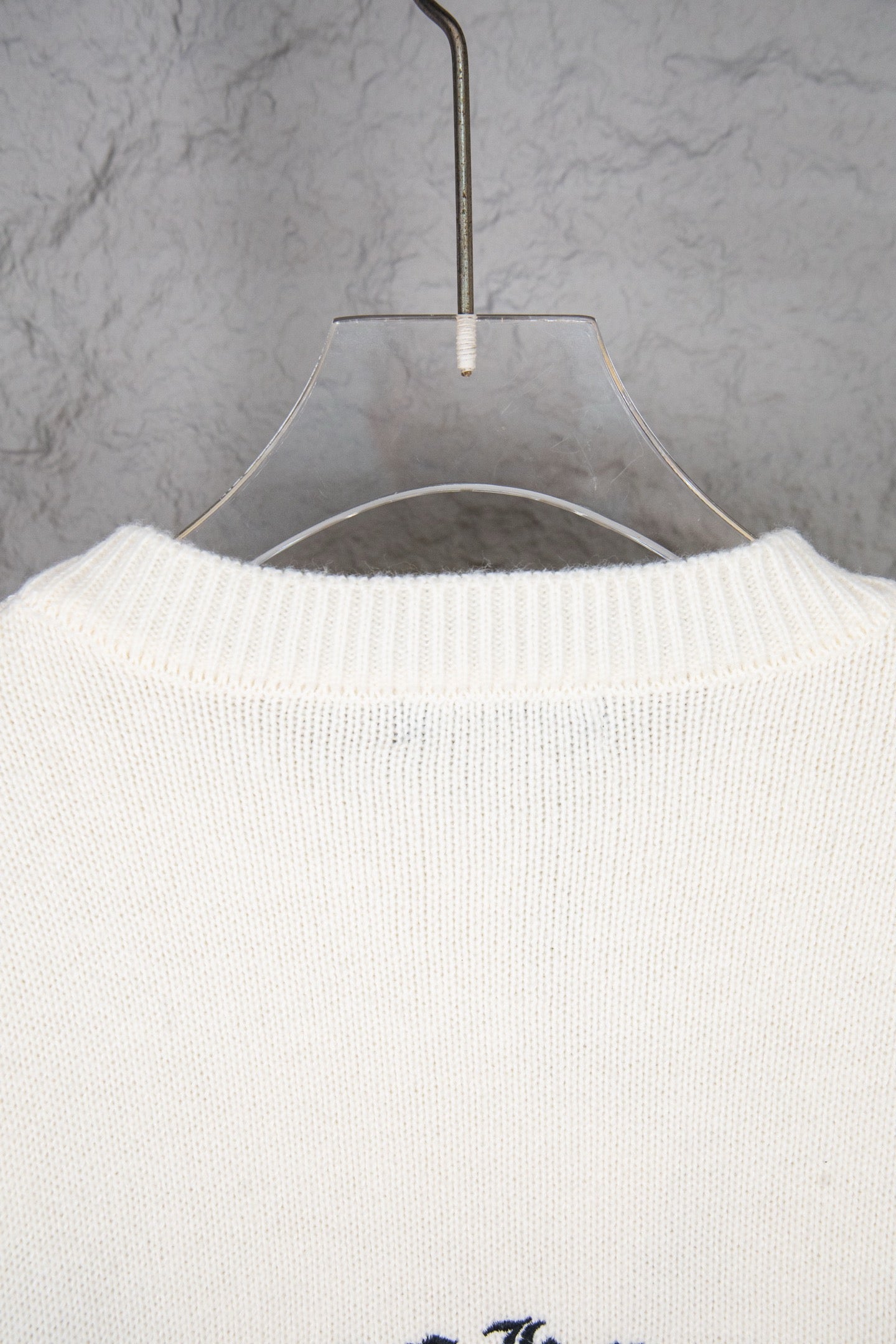 Cream knit sweater back with crewneck collar ribbing