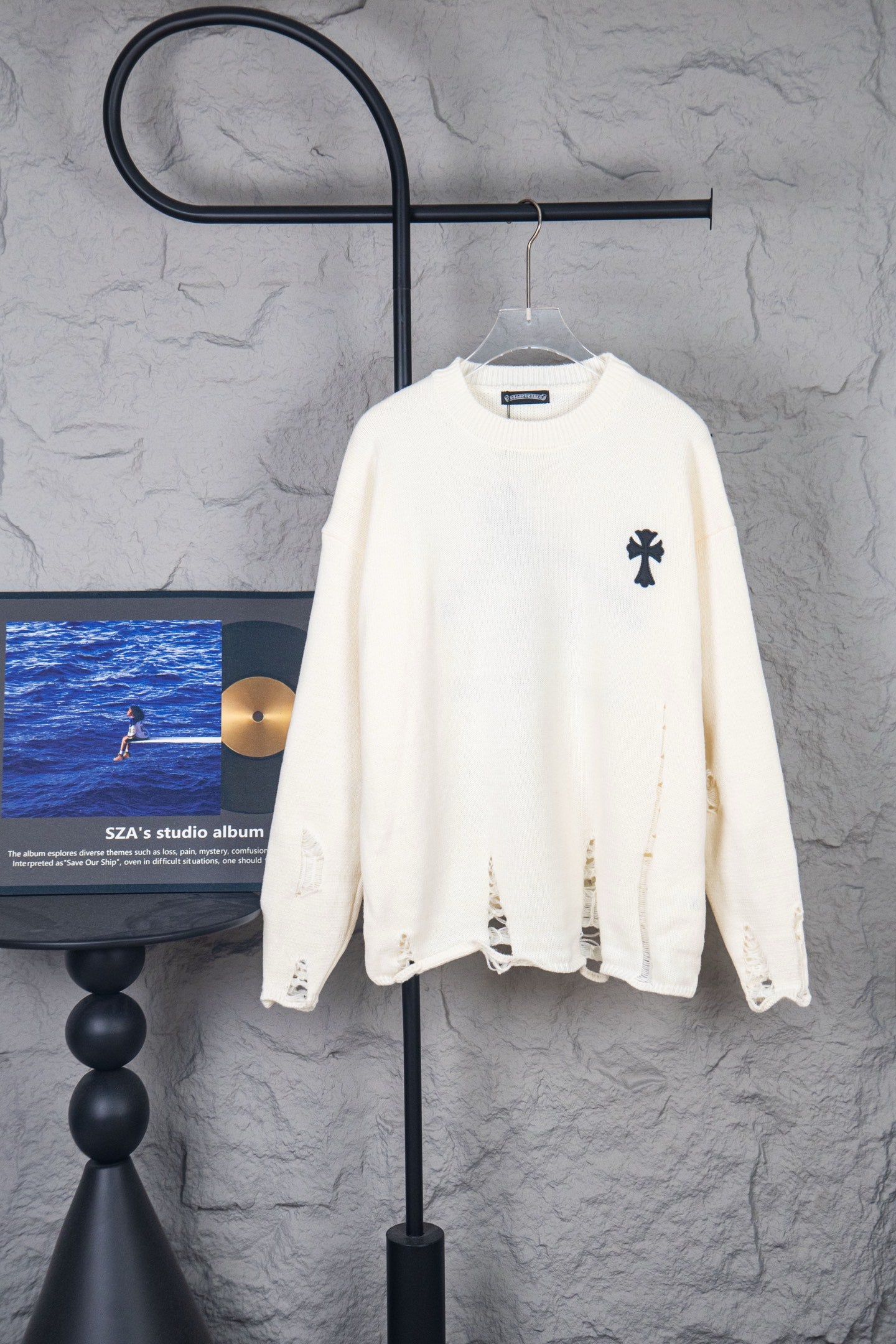 Cream long-sleeve sweater with crewneck and small black logo on front