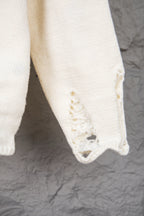 Cream sweater body with ribbed hem and distressed fabric patch