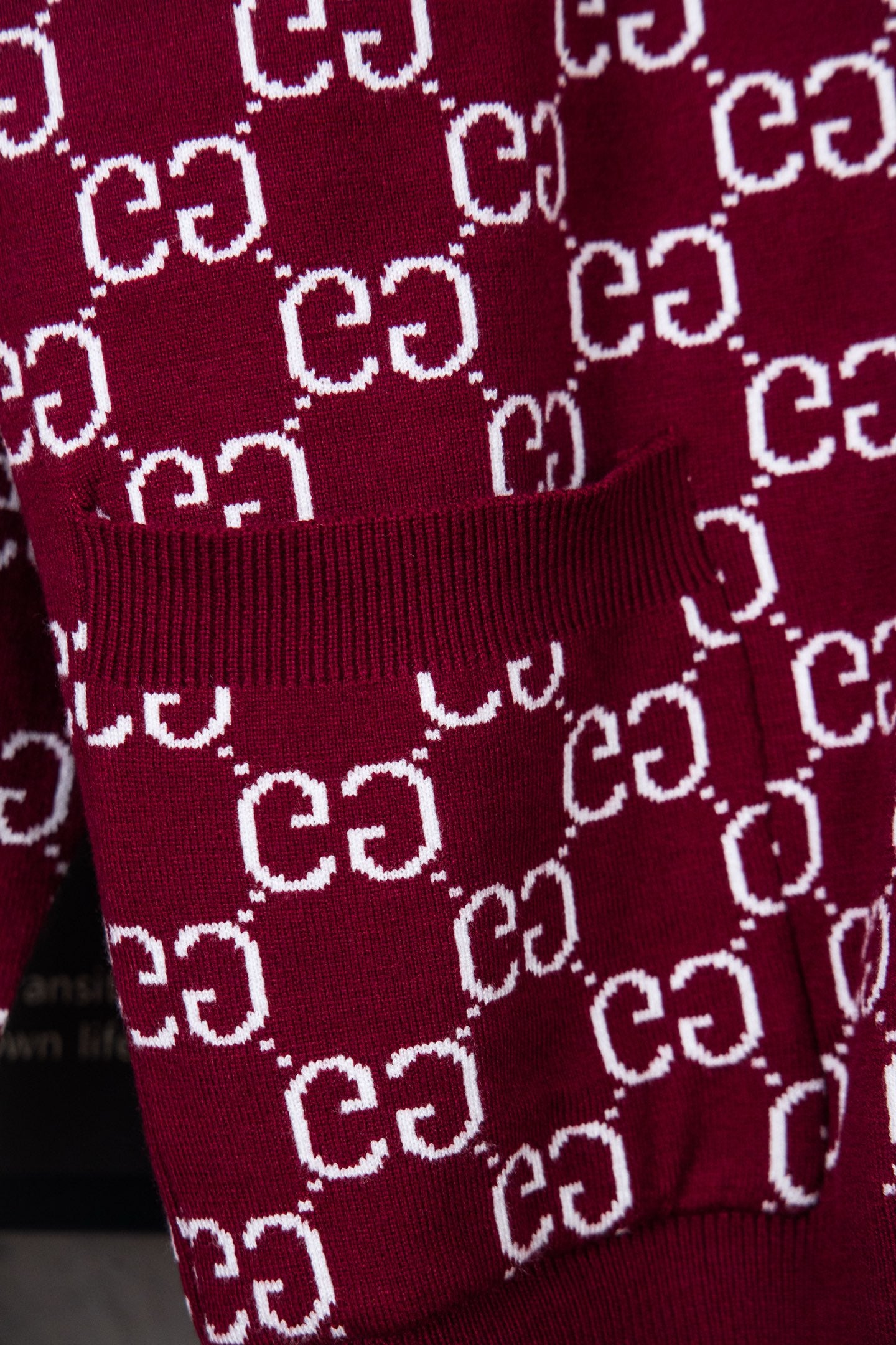 Gucci burgundy knit sweater with ribbed hem and repeating white GG pattern