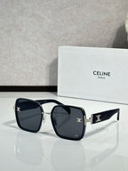 Celine sunglasses with dark frames and black lenses, gold-tone logo on arms