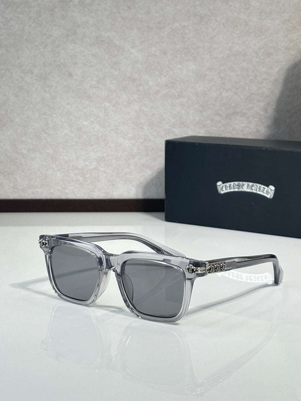 Chrome glasses with clear-silver frame, gray lenses, rhinestone-like detail on bridge