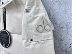 White puffer jacket side close-up with utility pocket and snap button tab