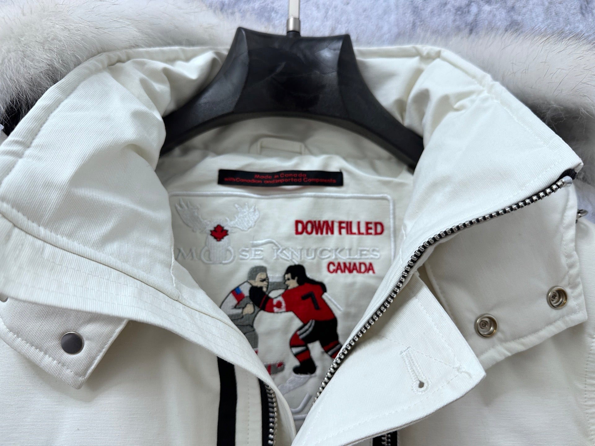 White puffer jacket lining with DOWN FILLED label and Canada graphic