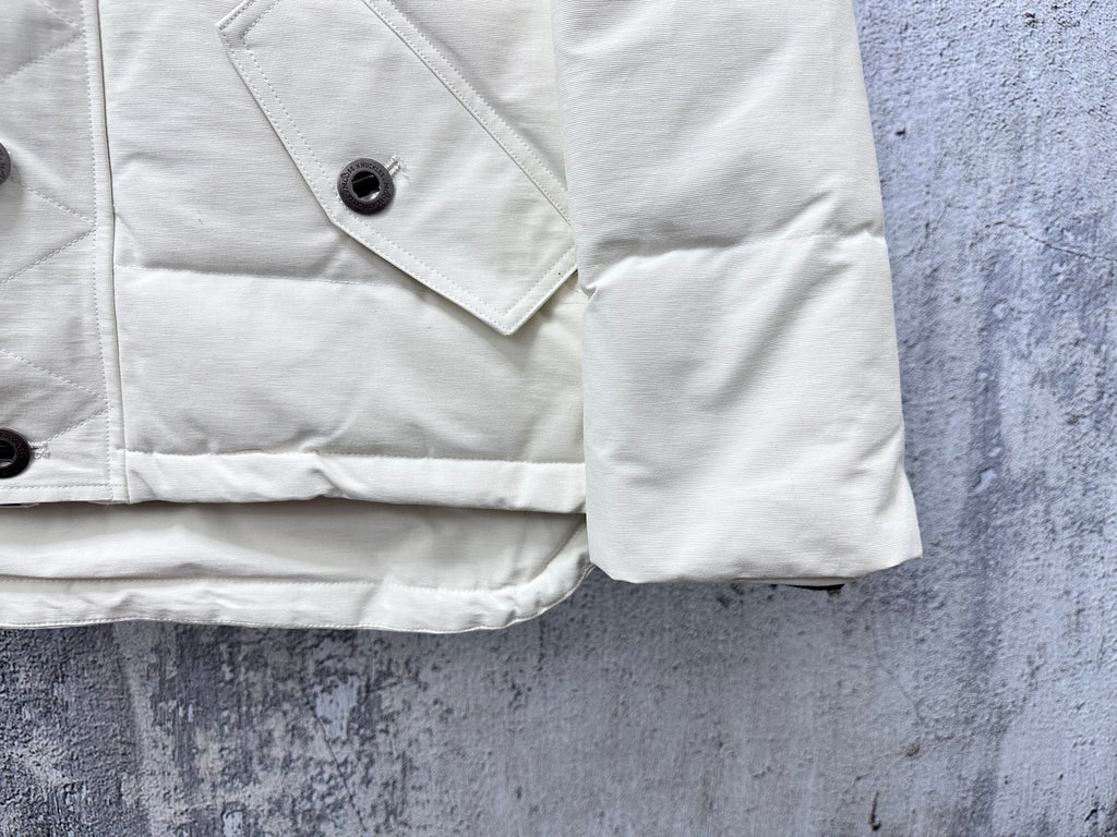 White puffer jacket sleeve and pocket with snap button and angled flap