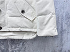 White puffer jacket sleeve and pocket with snap button and angled flap