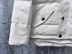 White puffer jacket hem and sleeve with snap buttons and stitched panels