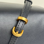 Balenciaga mini bag strap hardware close-up: gold D-ring on black leather