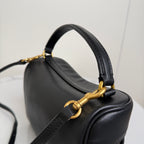 Black leather top handle of Balenciaga mini bag with gold link detail