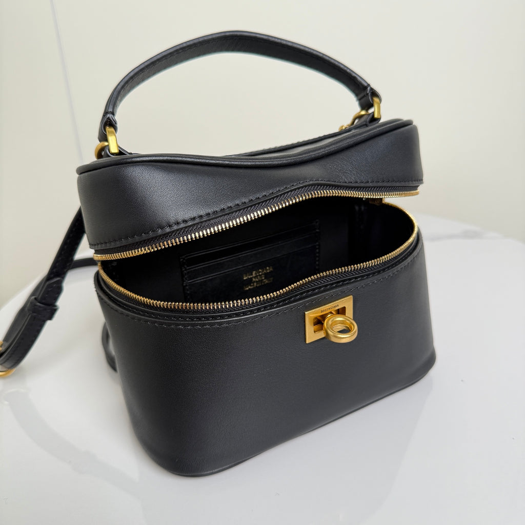Balenciaga mini bag front view in black leather with gold zipper and logo hardware