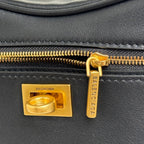 Balenciaga mini bag close-up: gold zipper pull, logo plate, and black tag detail