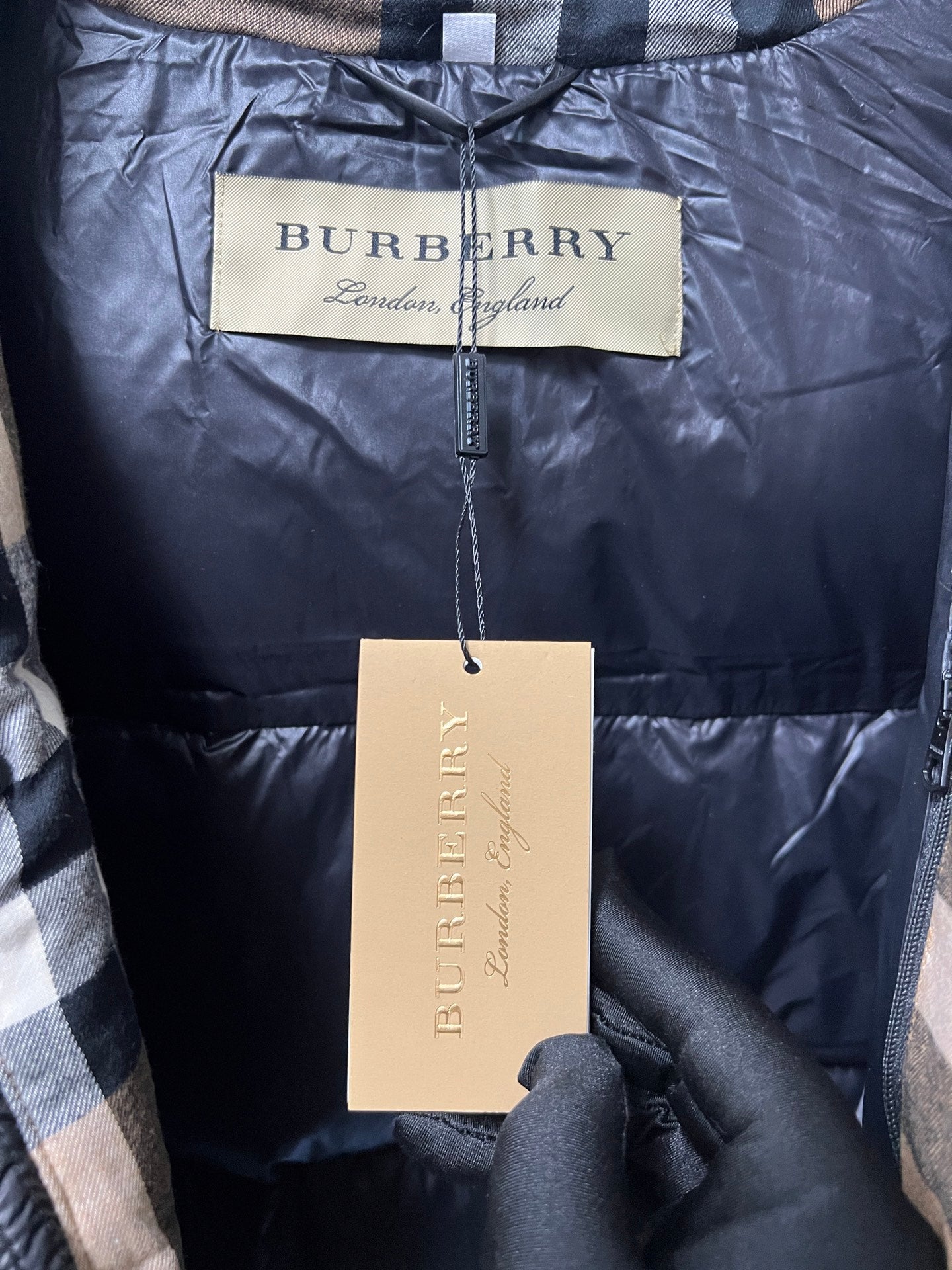 Navy puffer jacket with Burberry London England tags and front zipper pull