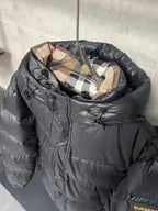 Dark puffer jacket with plaid inner hood and front zipper, quilted baffles