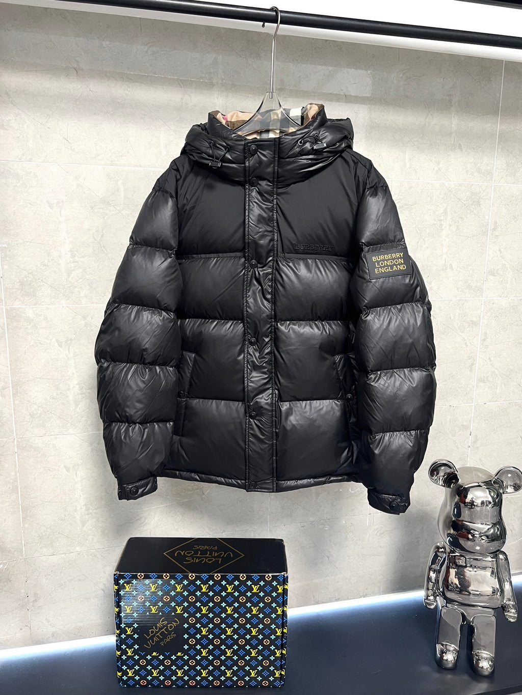 Black puffer jacket with full zipper and standing collar, quilted panels