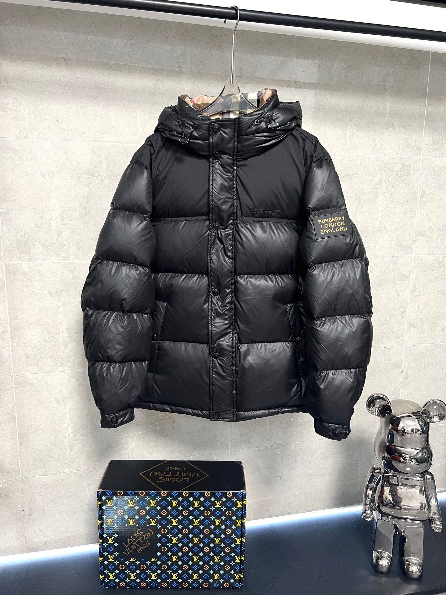 Black puffer jacket with full zipper and standing collar, quilted panels