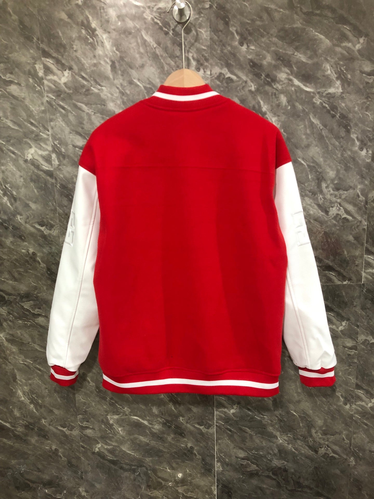 Givenchy red varsity jacket back view with white sleeves and striped hem trim