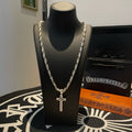 Cross pendant necklace with silver-tone chain, shown on a black display bust