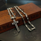 Multiple cross pendant necklaces on a wooden box with engraved motifs