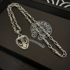 Silver chain necklace with heart crest pendant, laid on a black jewelry box