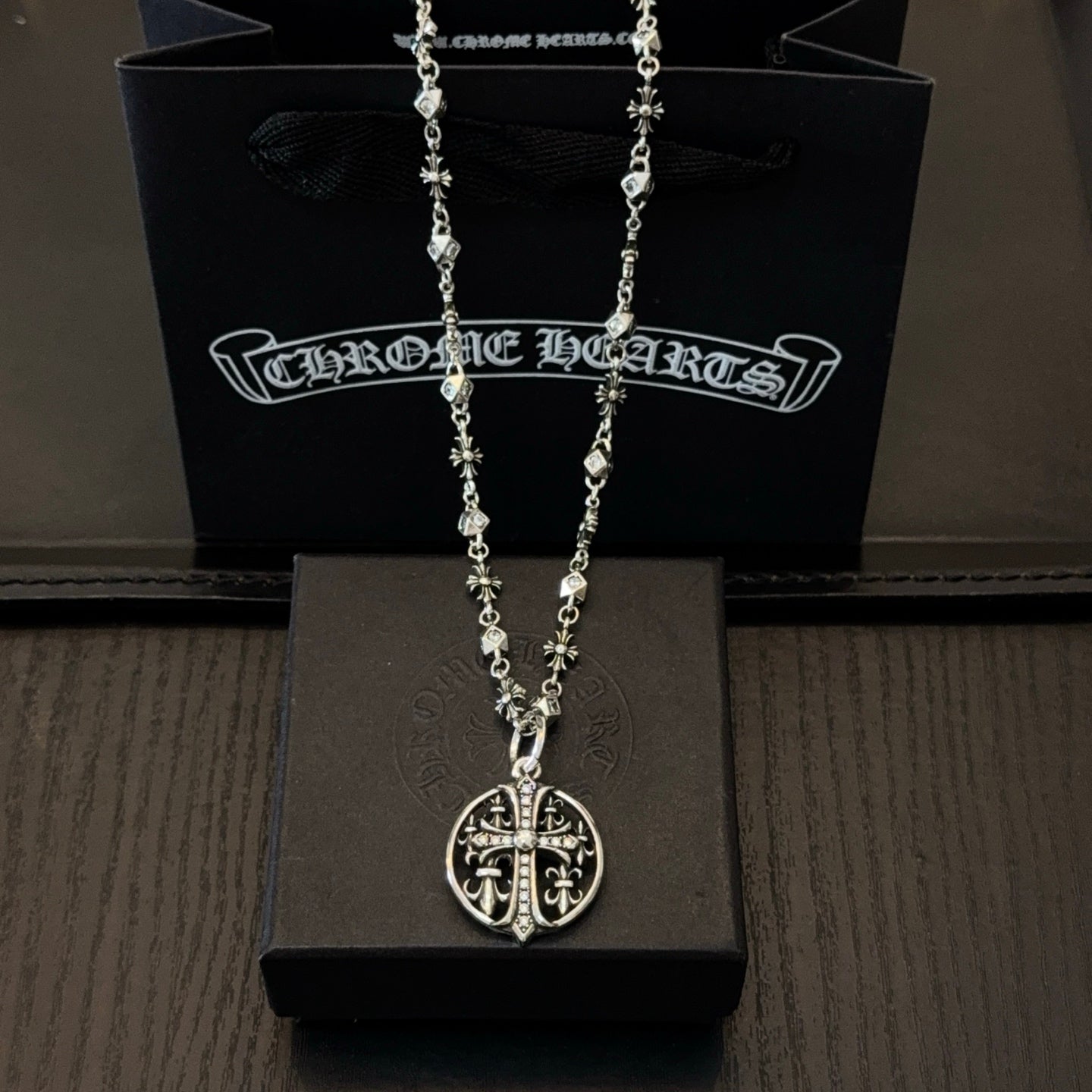 Silver-toned necklace with oval cross pendant and charm-link chain