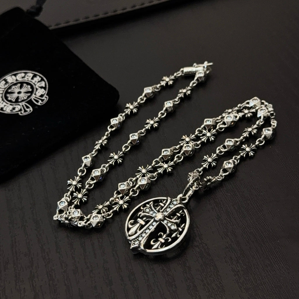 Silver-toned charm necklace with circular pendant and cross-and-flower link details