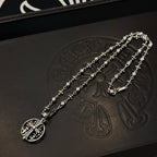 Silver-toned oval pendant necklace with charm-link chain and small floral accents