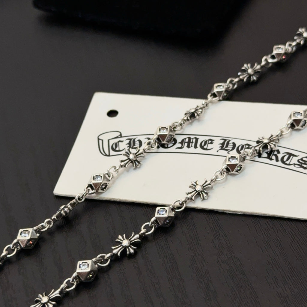 Silver-toned cross pendant necklace with square link accents on hanging tag